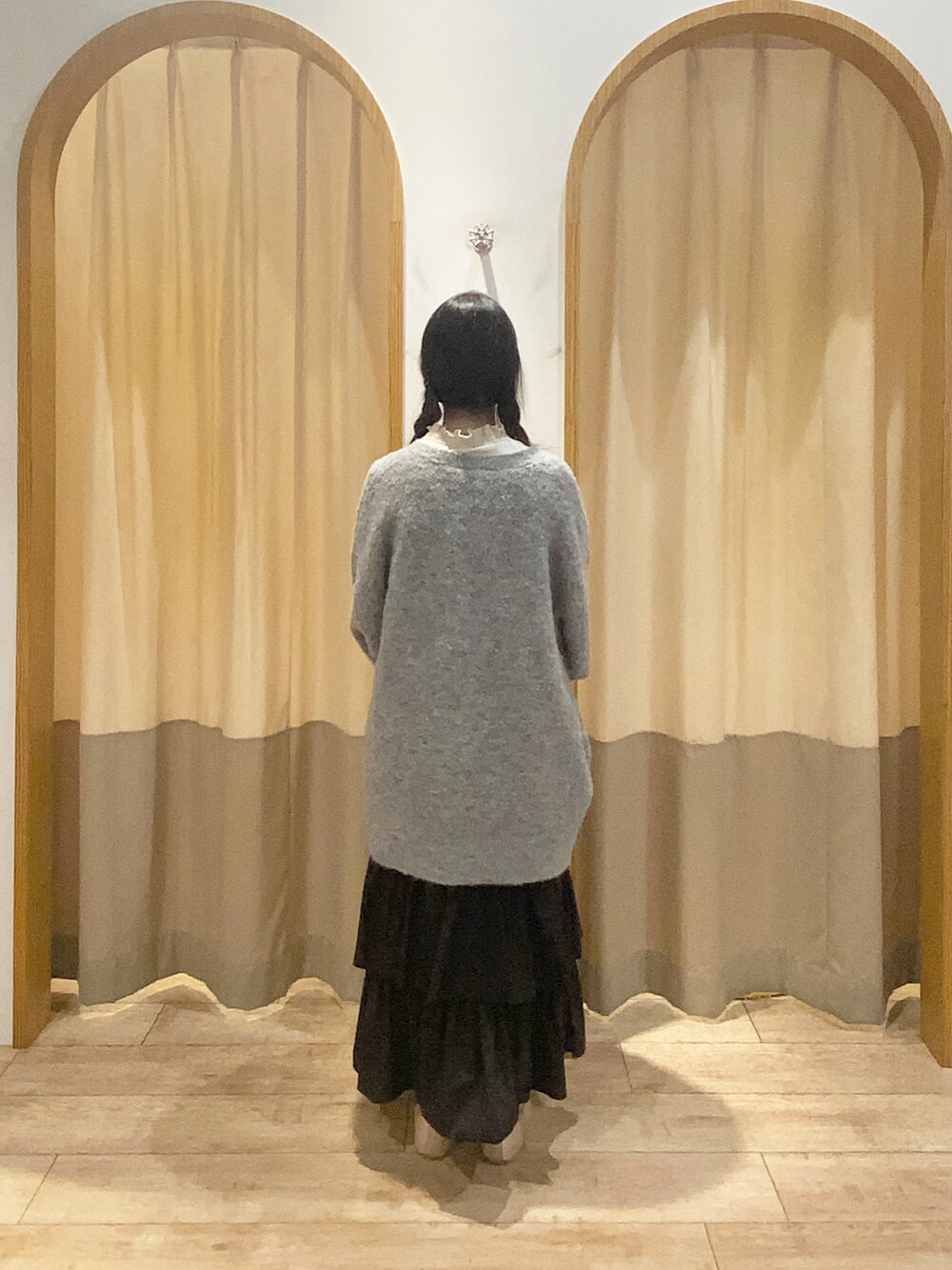 ホワイト系のTシャツ/カットソー、グレー系のワンピース、ブラック系のスカートを着用したレディースの秋コーディネートの3枚目の写真