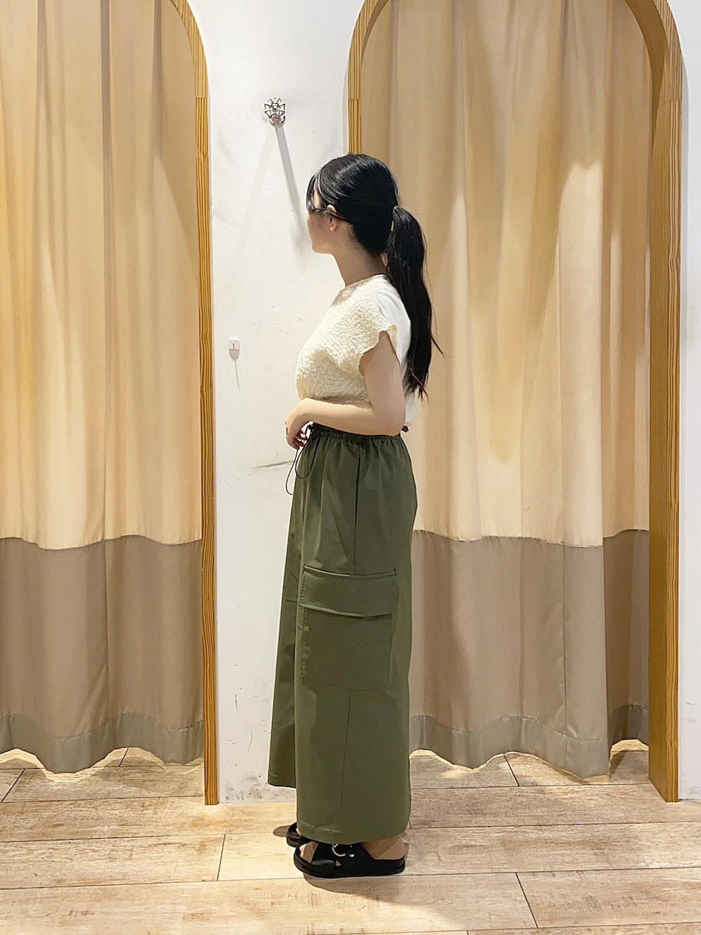 ホワイト系のTシャツ/カットソー、グリーン系のスカート、ブラック系のハンドバッグを着用したレディースの夏コーディネートの2枚目の写真