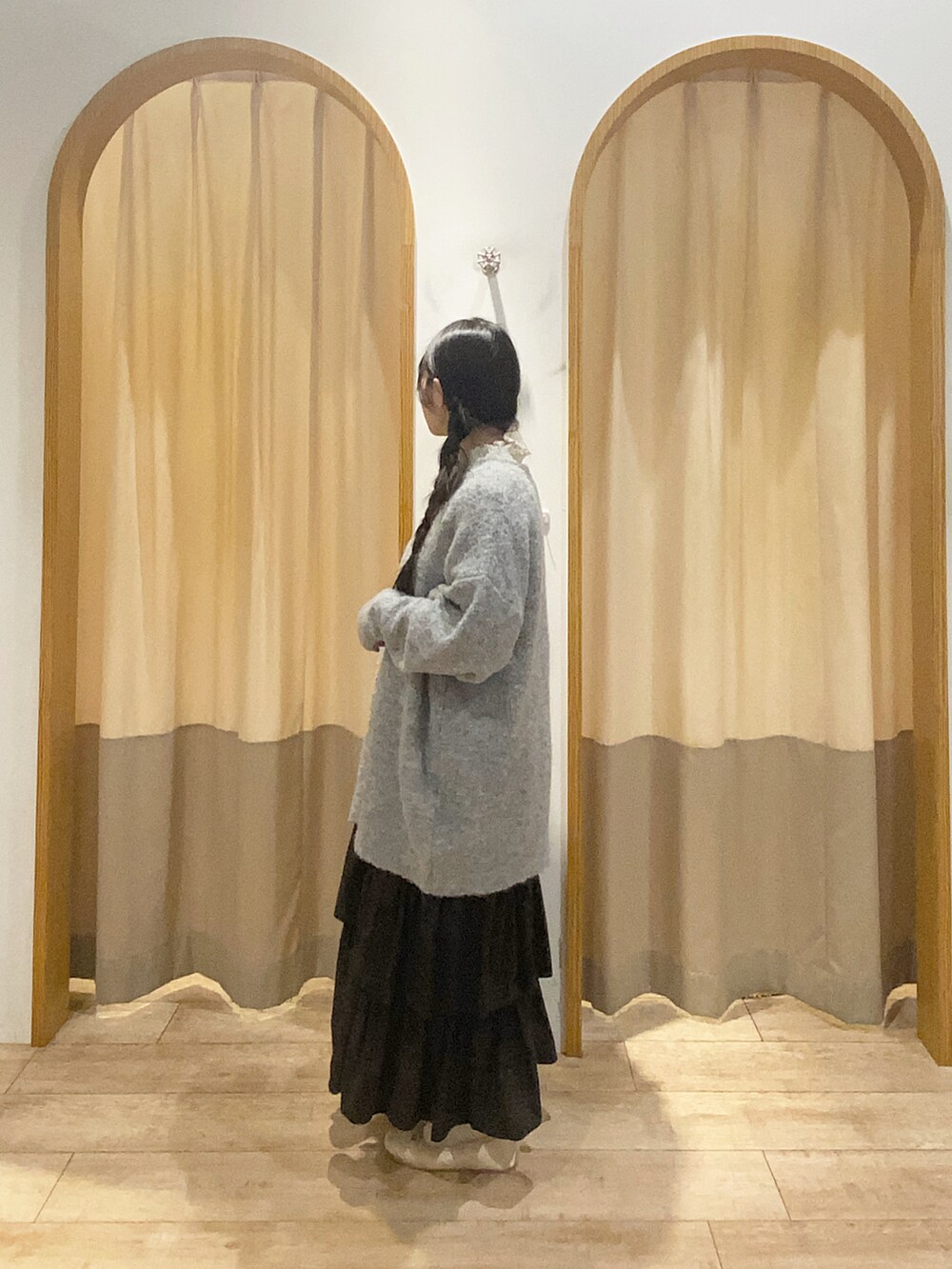 ホワイト系のTシャツ/カットソー、グレー系のワンピース、ブラック系のスカートを着用したレディースの秋コーディネートの2枚目の写真