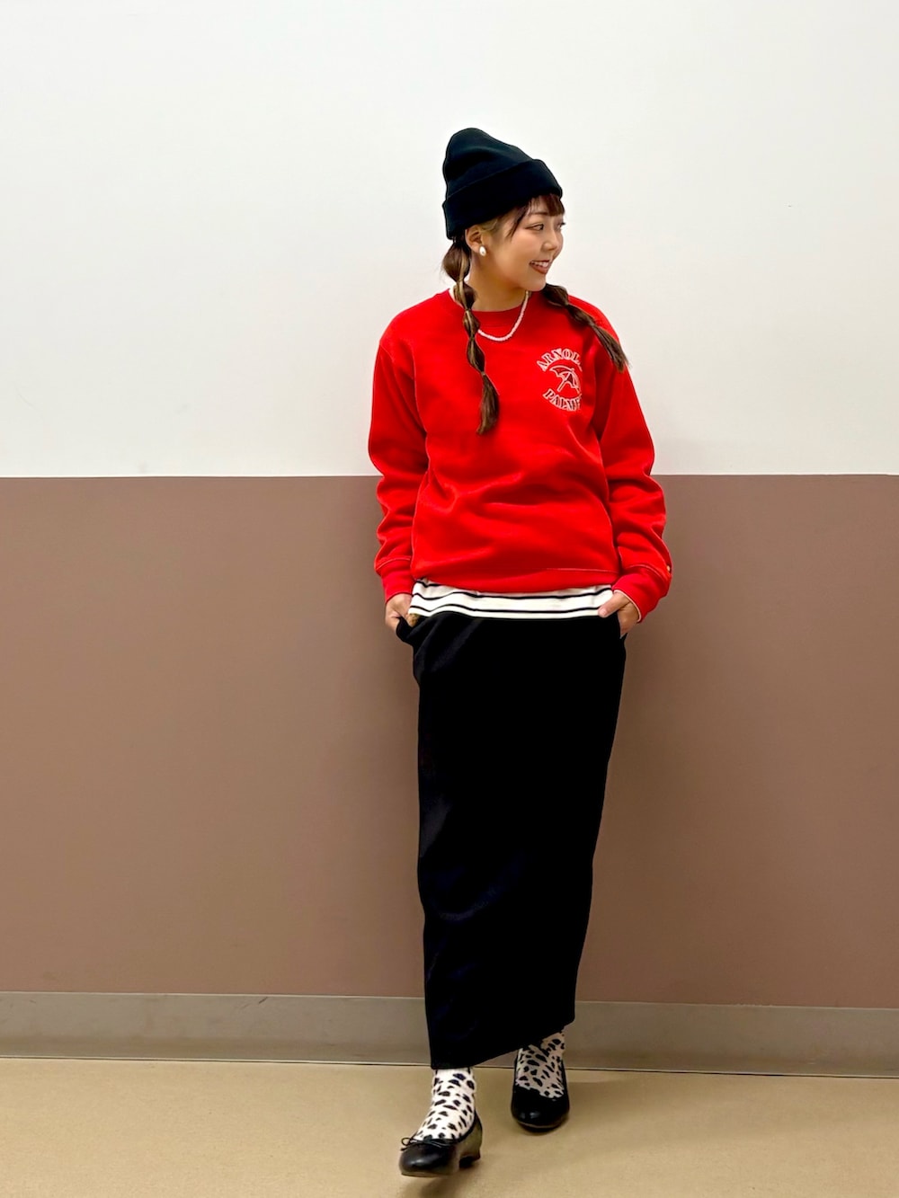 レッド系のスウェット、ブラック系のスカート、ブラック系のパンプスを着用したレディースの冬コーディネートの3枚目の写真