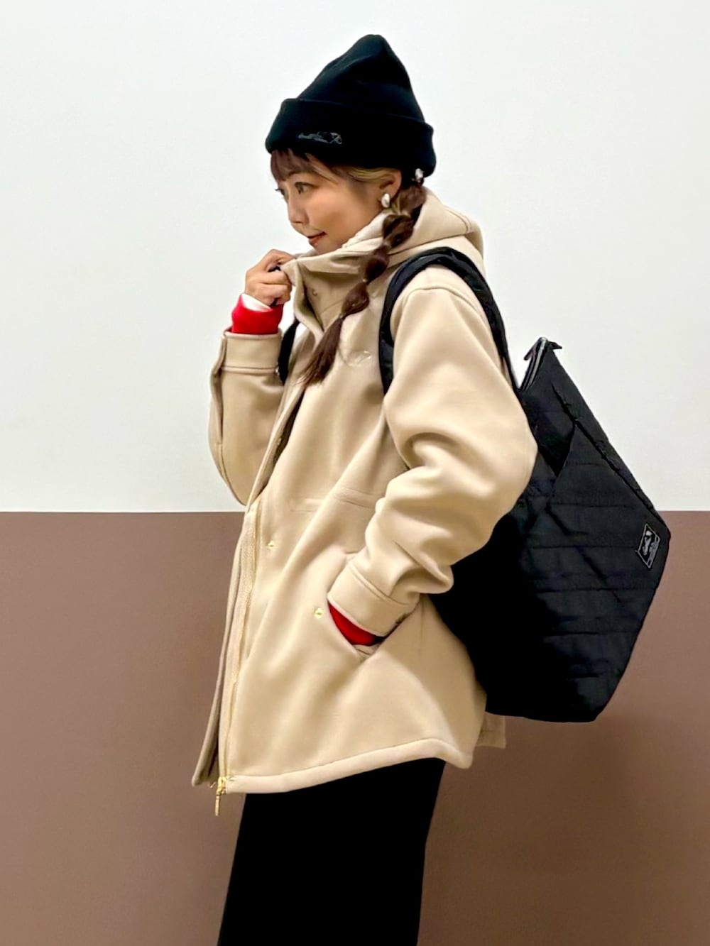 レッド系のスウェット、ブラック系のスカート、ブラック系のパンプスを着用したレディースの冬コーディネートの2枚目の写真