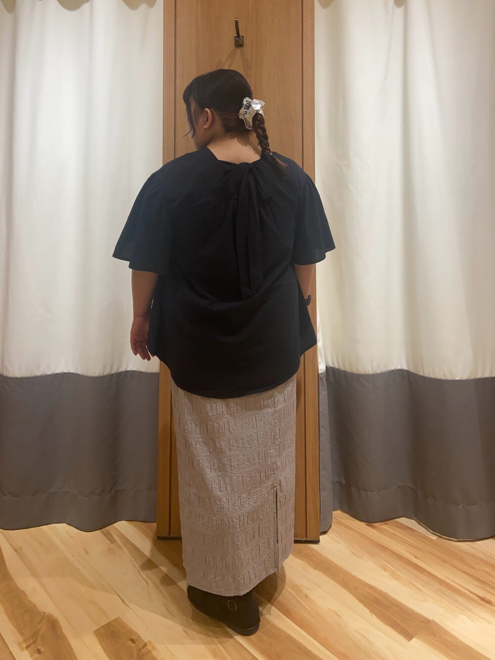 ブラック系のシャツ/ブラウス、グレー系のスカート、ブラック系のサンダルを着用したレディースの夏コーディネートの2枚目の写真