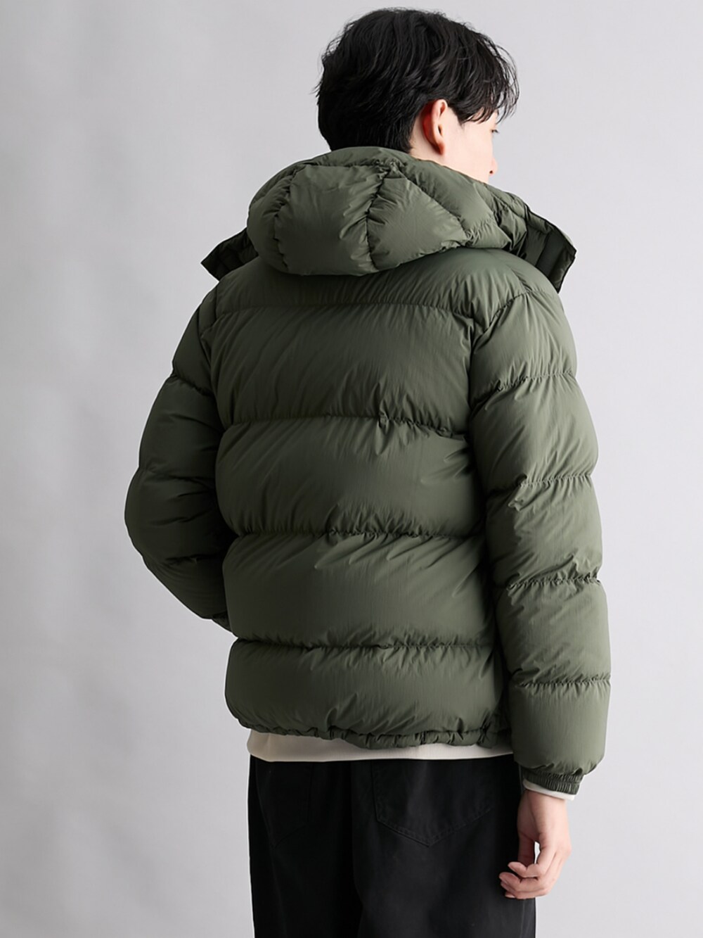 ブラック系のパンツ、ベージュ系のTシャツ/カットソー、グリーン系のジャケット/アウターを着用したメンズの秋コーディネートの2枚目の写真