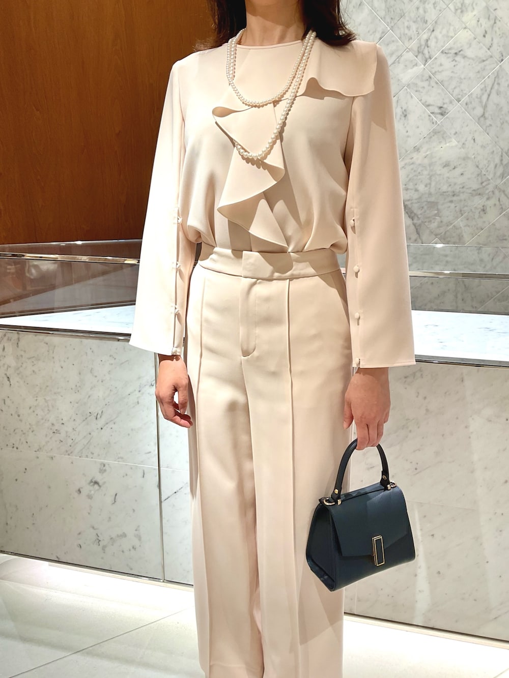 ベージュ系のシャツ/ブラウス、ベージュ系のその他パンツ、ブルー系のトートバッグを着用したレディースの冬コーディネートの6枚目の写真