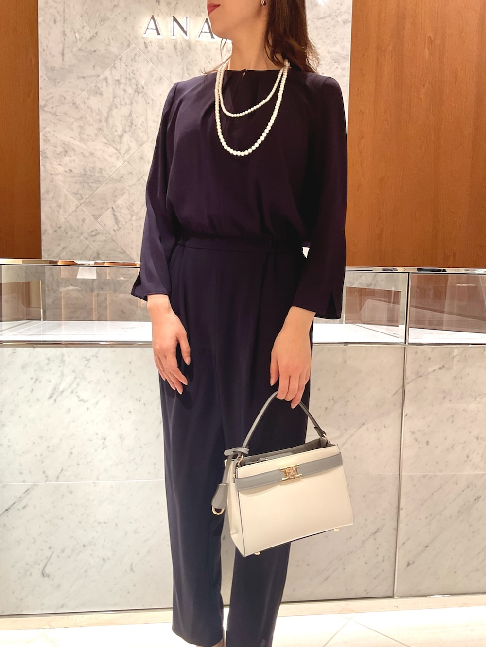 ブルー系のつなぎ/オールインワン、ホワイト系のハンドバッグ、ホワイト系のネックレスを着用したレディースの冬コーディネートの5枚目の写真