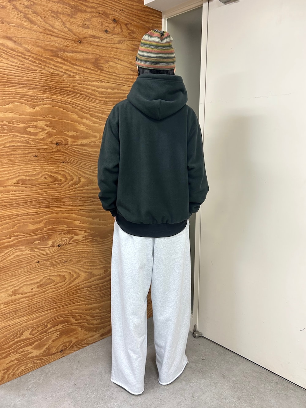 ブラック系のパーカー、グレー系のスウェットパンツ、ベージュ系のキャップを着用したメンズの秋コーディネートの2枚目の写真