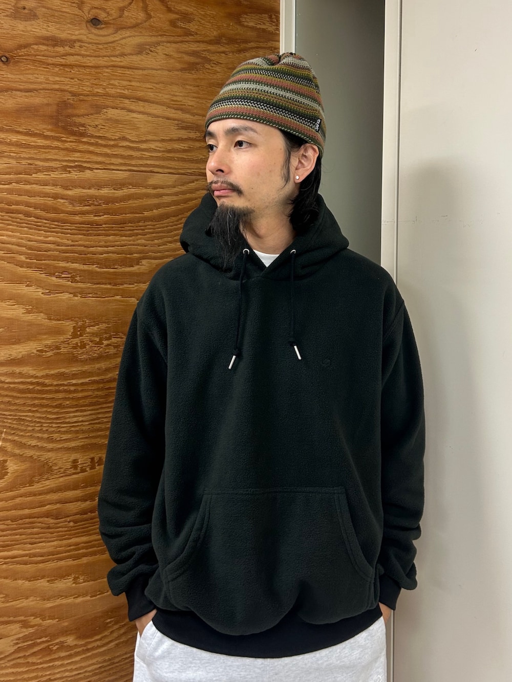 ブラック系のパーカー、グレー系のスウェットパンツ、ベージュ系のキャップを着用したメンズの秋コーディネートの3枚目の写真