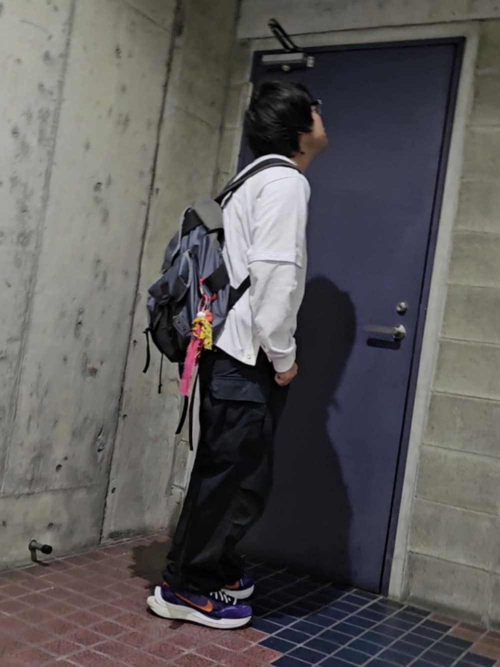 パープル系のスニーカー、ブラック系のカーゴパンツ、ホワイト系のTシャツ/カットソーを着用したメンズの秋コーディネートの3枚目の写真