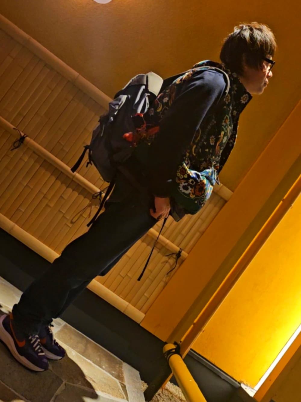 ブルー系のデニムパンツ、その他のダウンベスト、ブラック系のメガネを着用したメンズの秋コーディネートの3枚目の写真