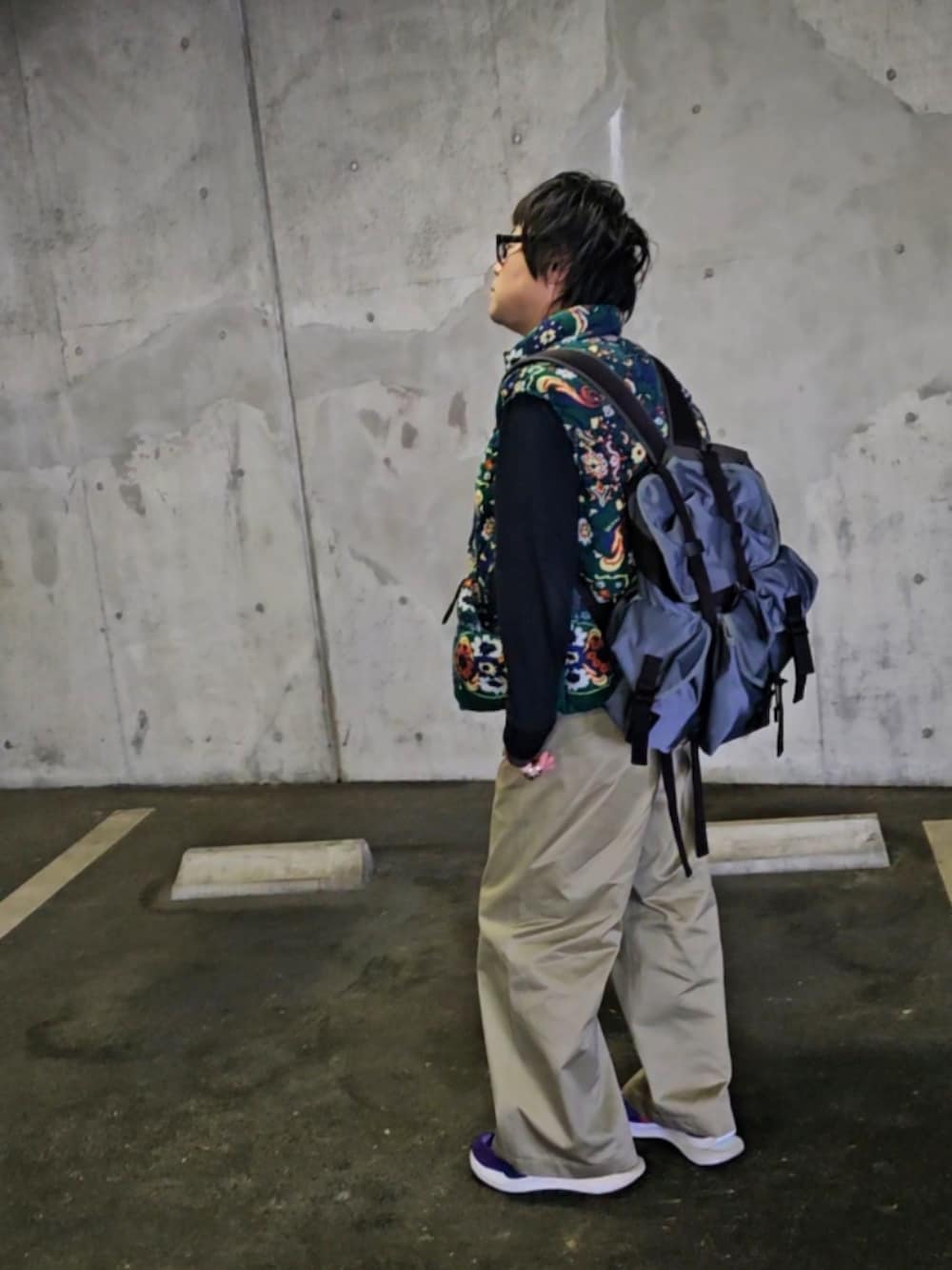 パープル系のスニーカー、ベージュ系のチノパンツ、その他のダウンベストを着用したメンズの秋コーディネートの2枚目の写真