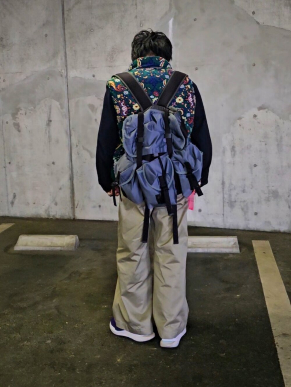 パープル系のスニーカー、ベージュ系のチノパンツ、その他のダウンベストを着用したメンズの秋コーディネートの3枚目の写真