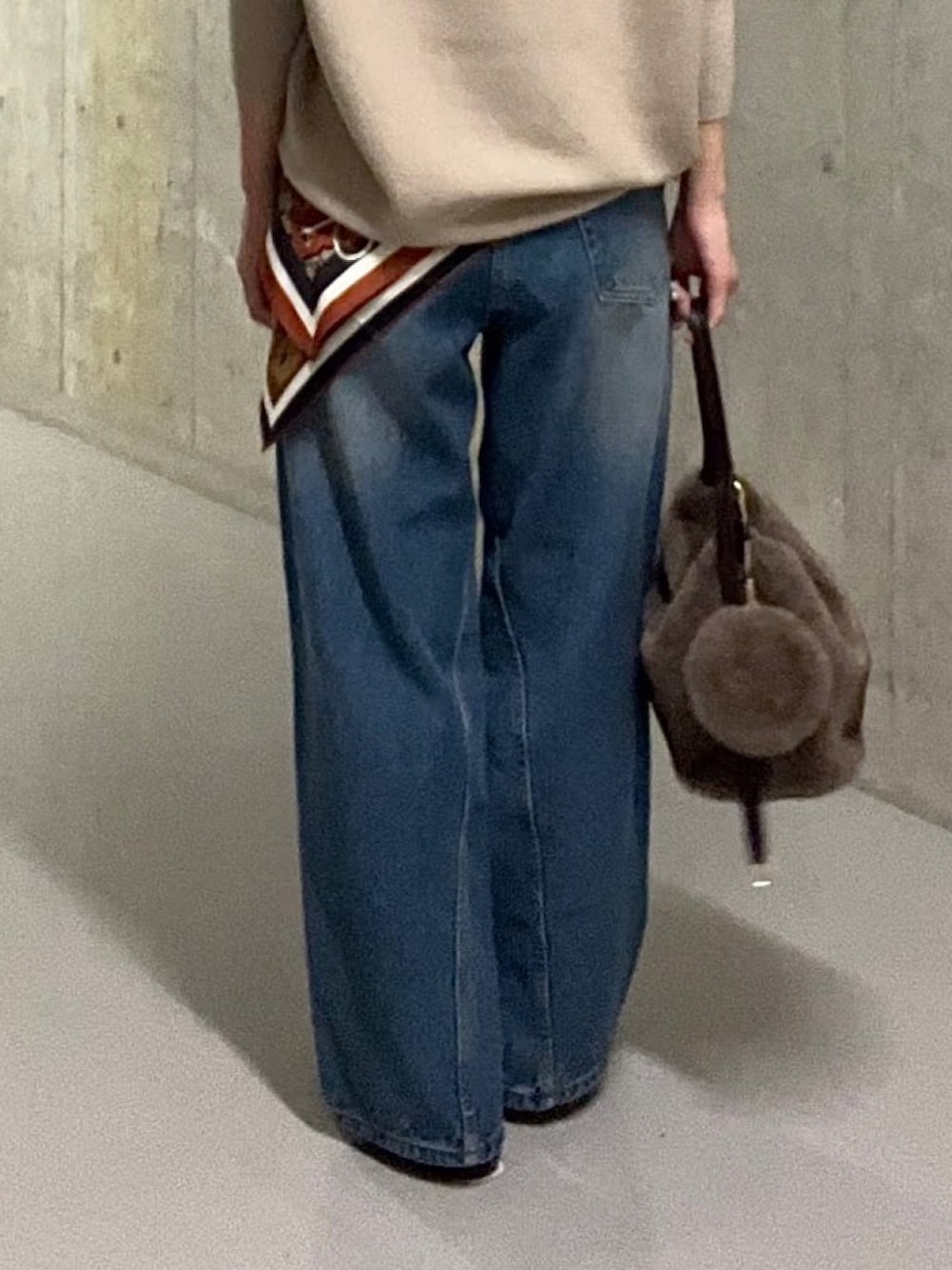 ブルー系のデニムパンツ、ブラウン系のハンドバッグ、ブラウン系のその他シューズを着用したレディースの秋コーディネートの9枚目の写真