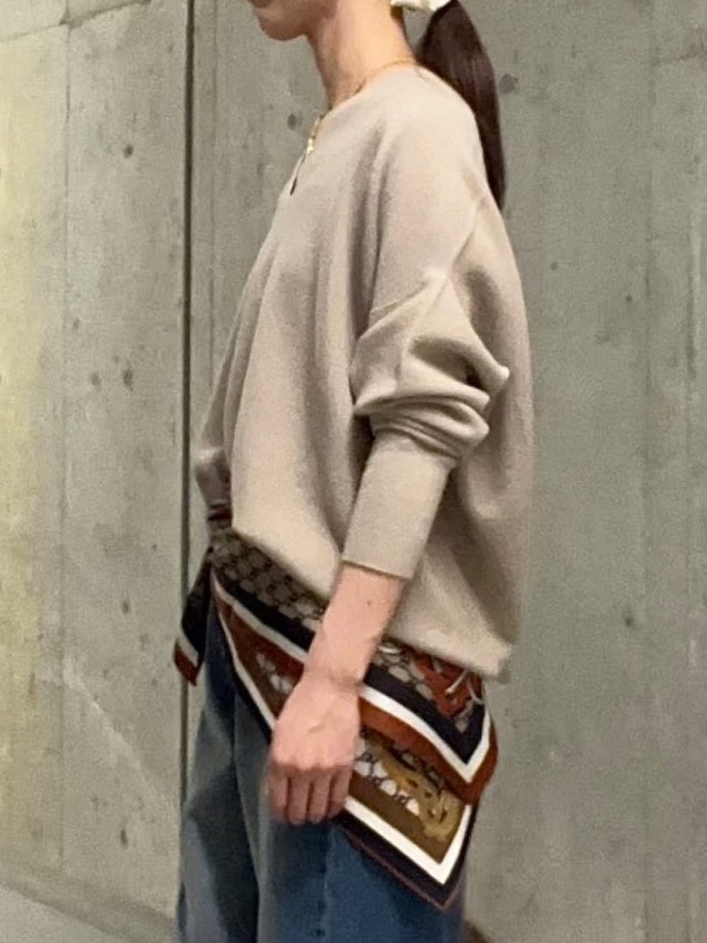 ブルー系のデニムパンツ、ブラウン系のハンドバッグ、ブラウン系のその他シューズを着用したレディースの秋コーディネートの5枚目の写真