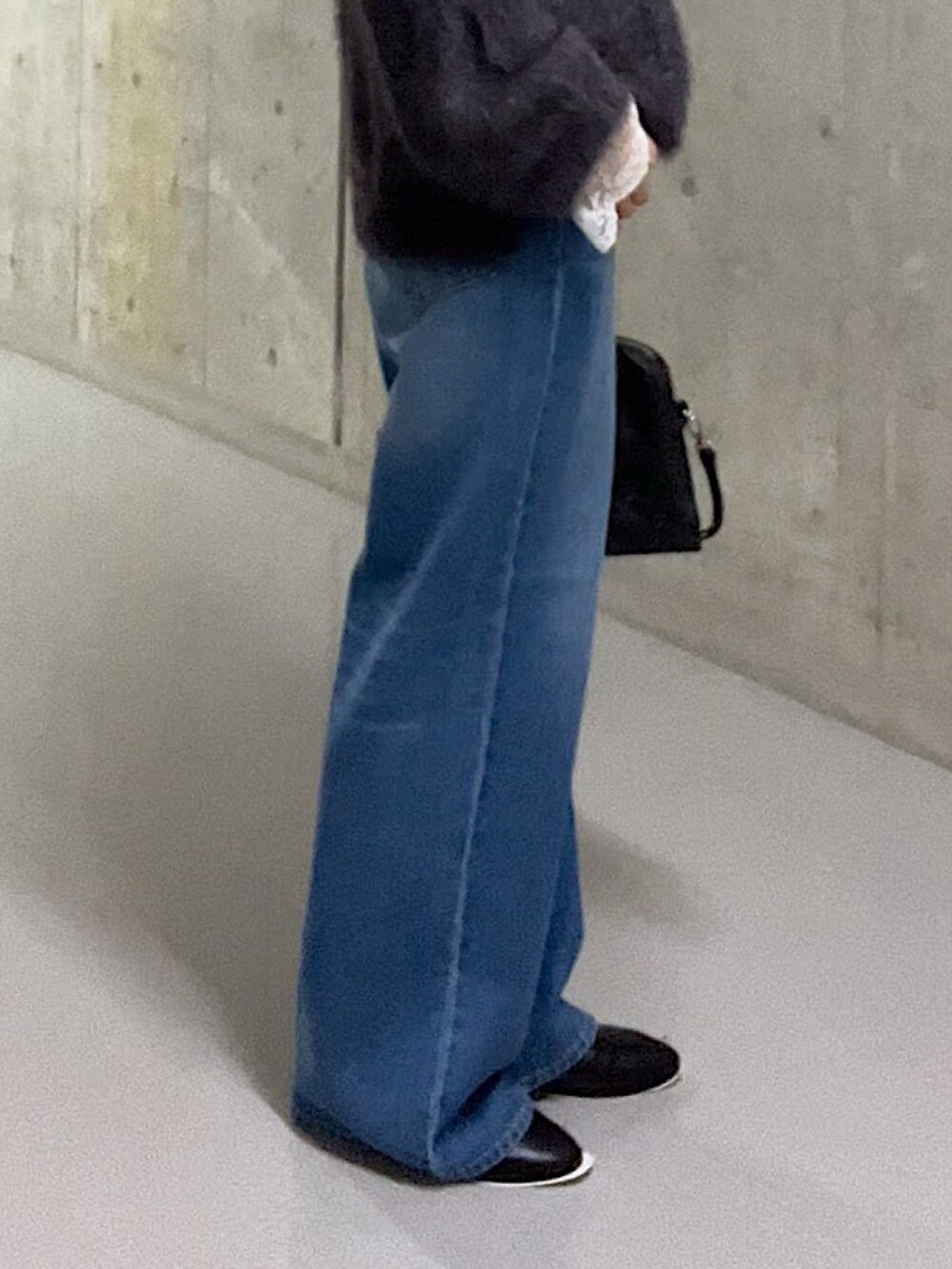 グレー系のニット/セーター、ホワイト系のシャツ/ブラウス、ブルー系のデニムパンツを着用したレディースの秋コーディネートの8枚目の写真