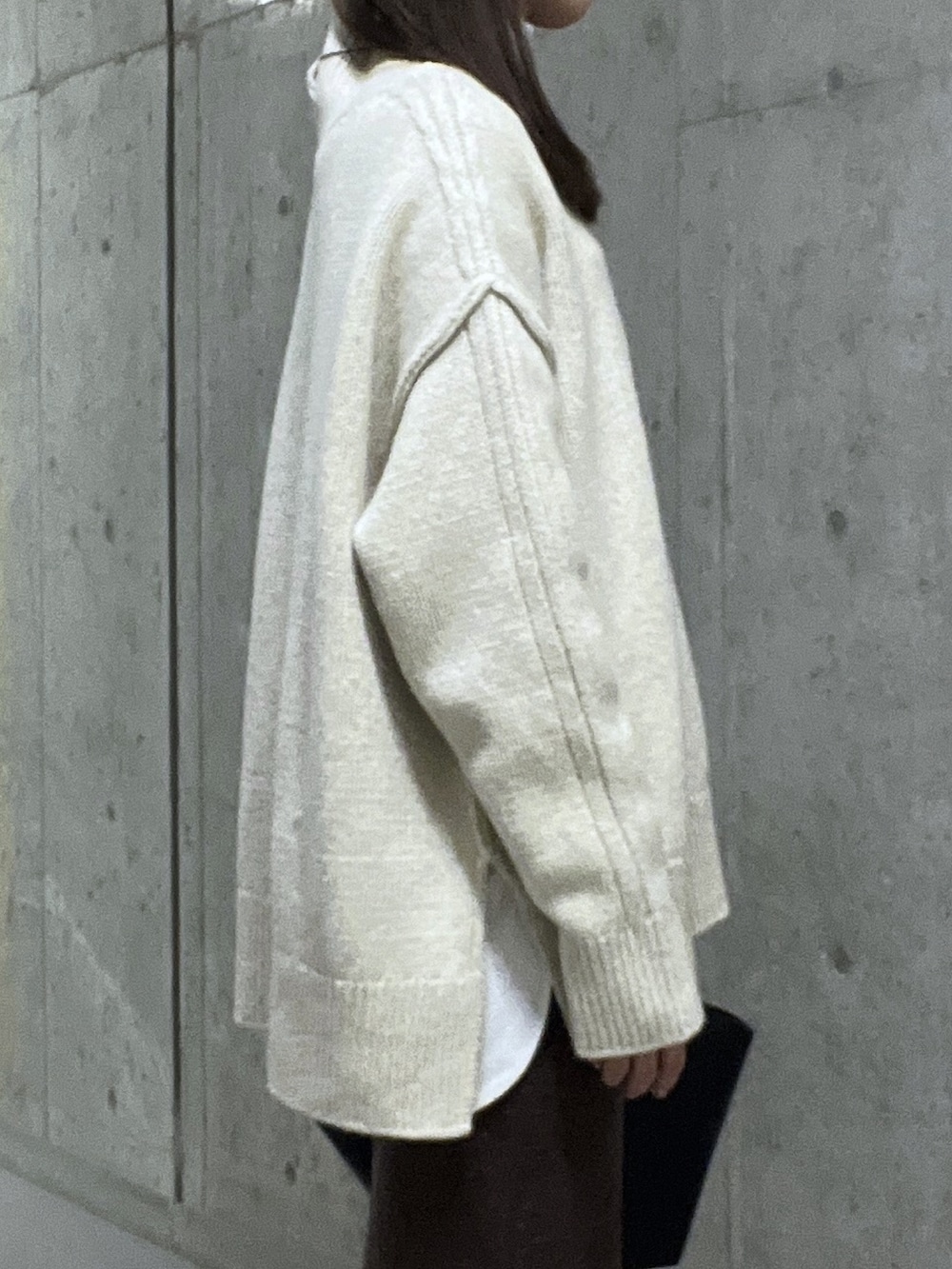 ホワイト系のニット/セーター、ブラウン系のスカート、ブラック系のブーツを着用したレディースの秋コーディネートの5枚目の写真