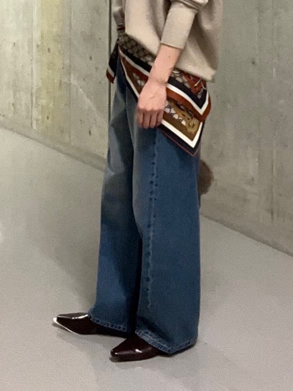 ブルー系のデニムパンツ、ブラウン系のハンドバッグ、ブラウン系のその他シューズを着用したレディースの秋コーディネートの8枚目の写真