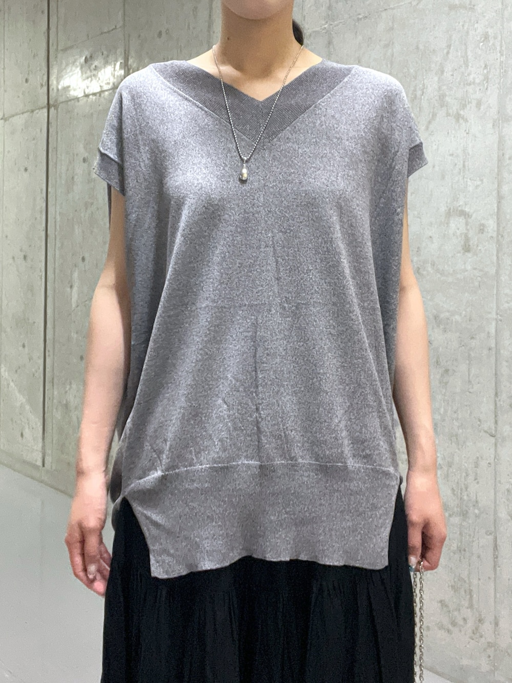 ブラック系のサンダル、グレー系のニット/セーター、ブラック系のハンドバッグを着用したレディースの夏コーディネートの4枚目の写真
