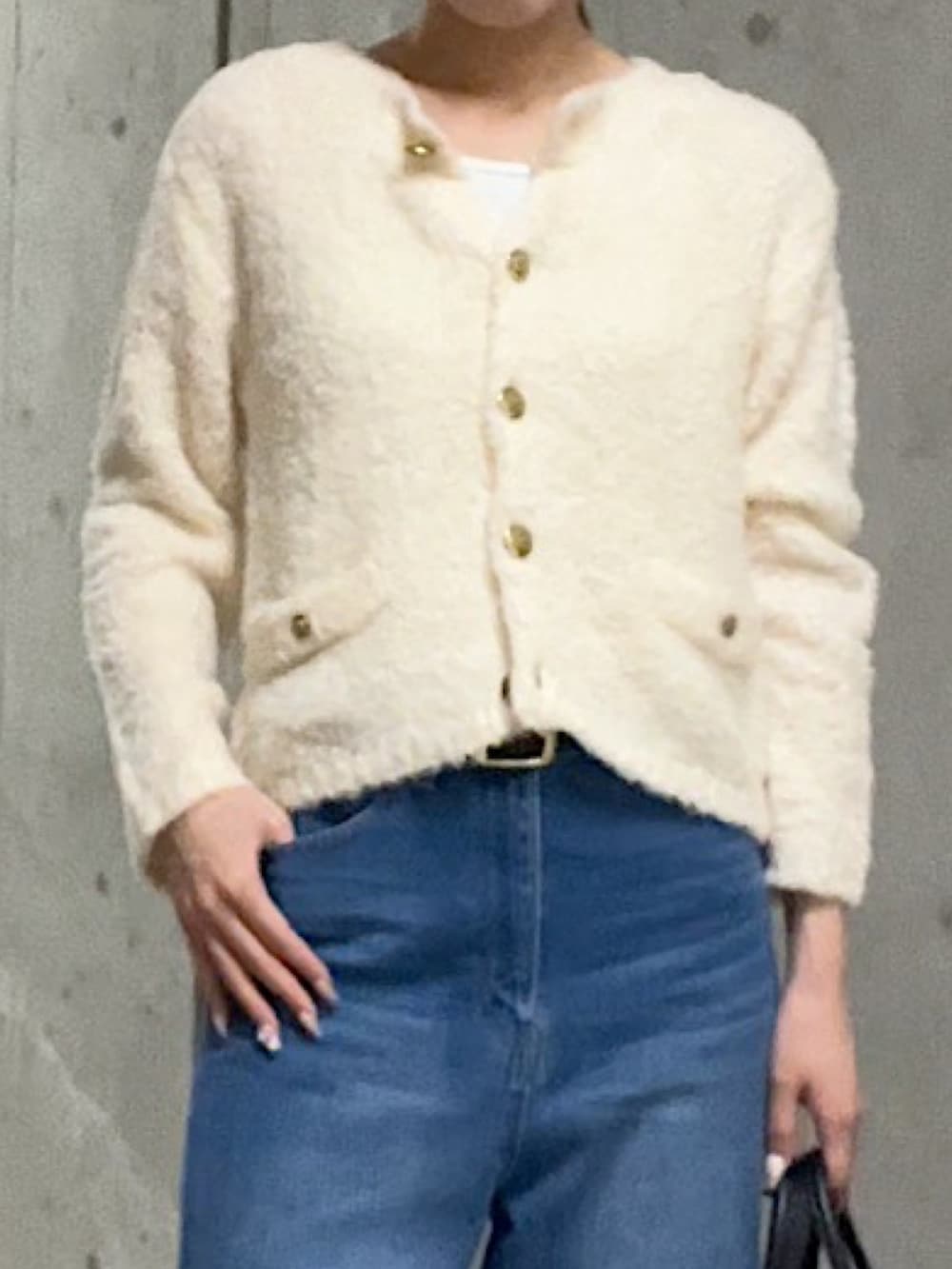 ホワイト系のカーディガン/ボレロ、ブルー系のデニムパンツ、ブラック系のローファーを着用したレディースの秋コーディネートの4枚目の写真