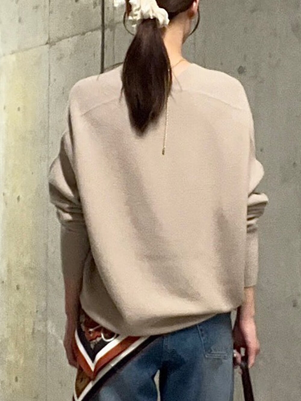 ブルー系のデニムパンツ、ブラウン系のハンドバッグ、ブラウン系のその他シューズを着用したレディースの秋コーディネートの6枚目の写真