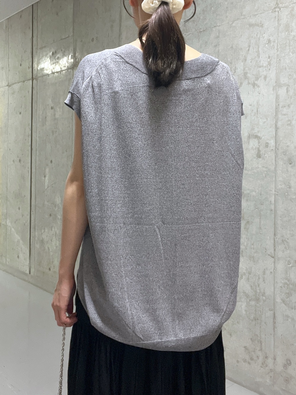 ブラック系のサンダル、グレー系のニット/セーター、ブラック系のハンドバッグを着用したレディースの夏コーディネートの6枚目の写真