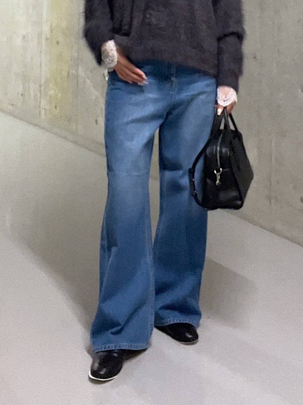 グレー系のニット/セーター、ホワイト系のシャツ/ブラウス、ブルー系のデニムパンツを着用したレディースの秋コーディネートの7枚目の写真