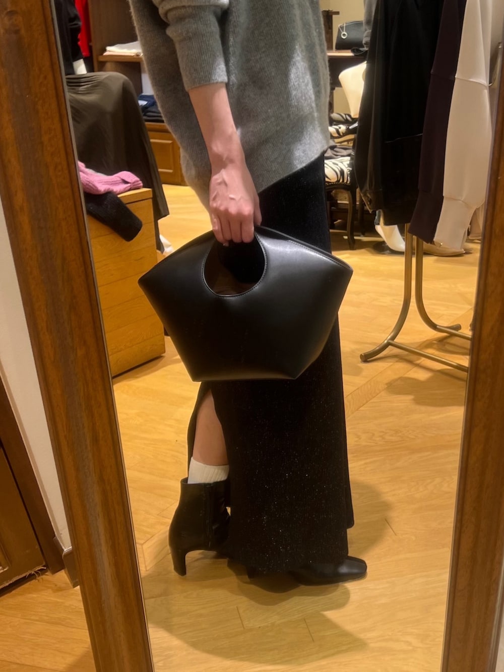 グレー系のニット/セーター、ブラック系のスカート、ブラック系のブーツを着用したレディースの冬コーディネートの5枚目の写真