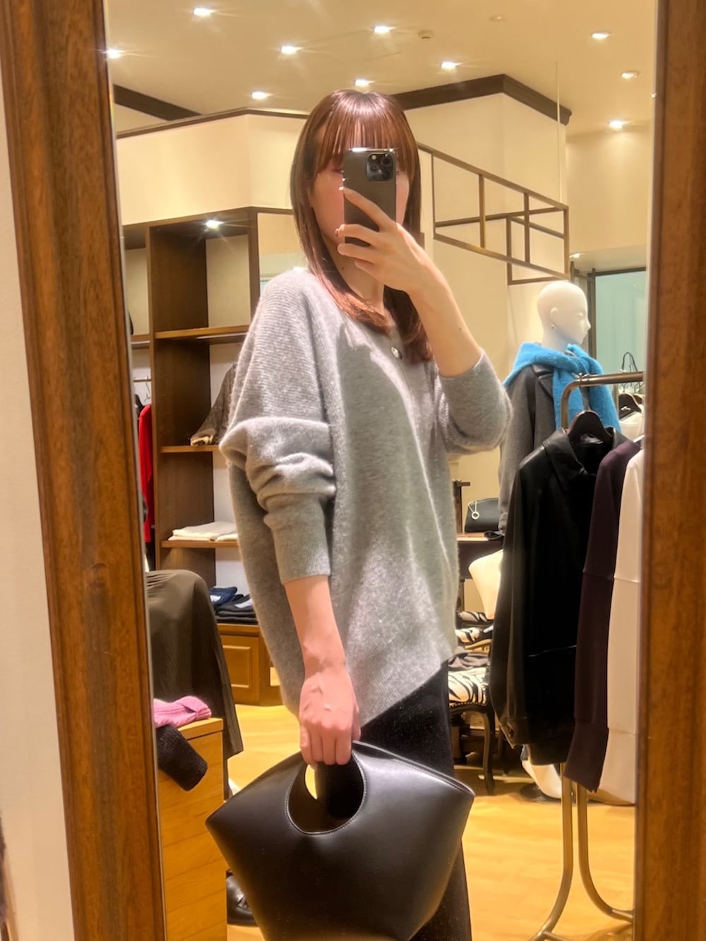 グレー系のニット/セーター、ブラック系のスカート、ブラック系のブーツを着用したレディースの冬コーディネートの3枚目の写真