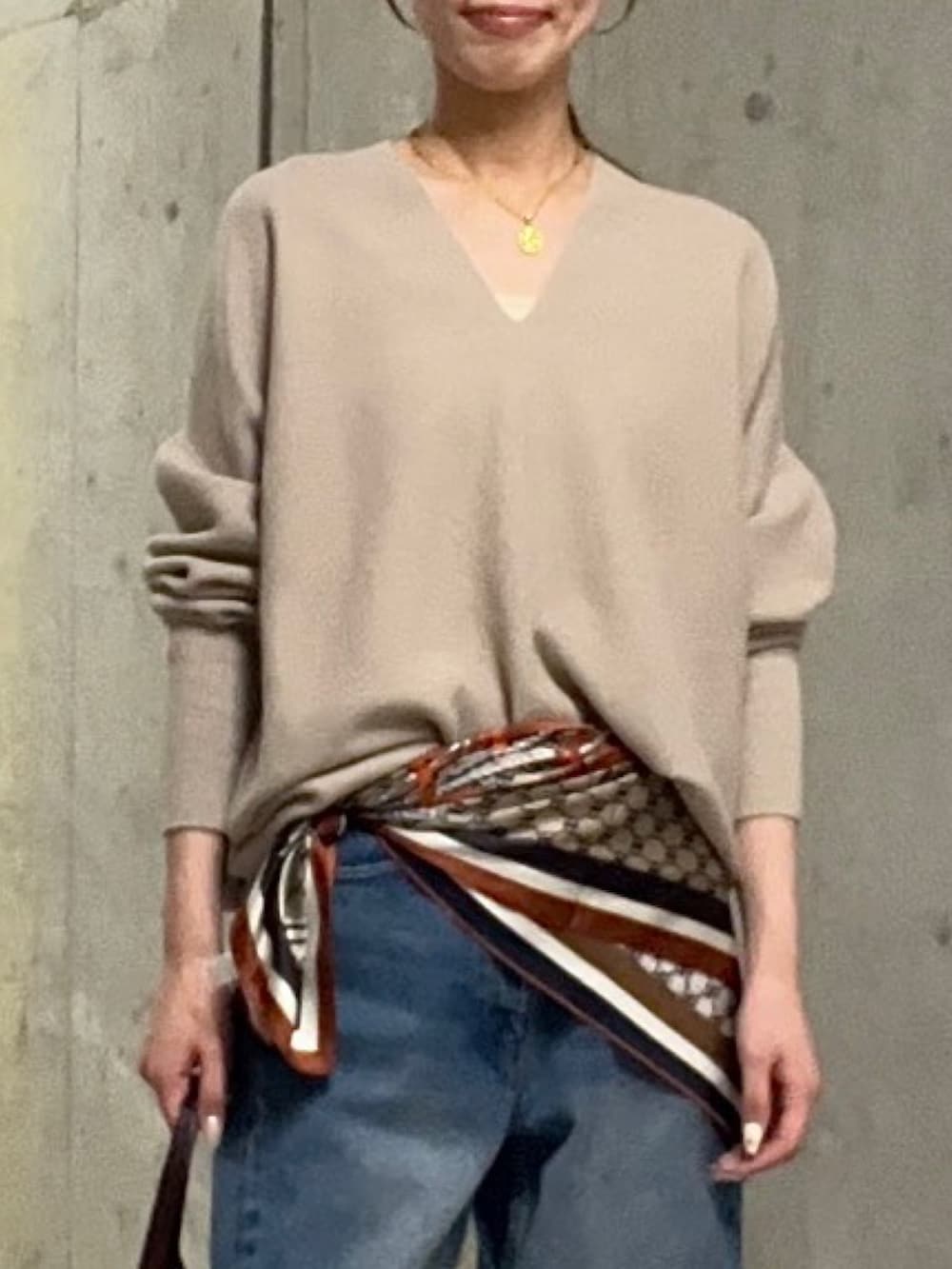 ブルー系のデニムパンツ、ブラウン系のハンドバッグ、ブラウン系のその他シューズを着用したレディースの秋コーディネートの4枚目の写真