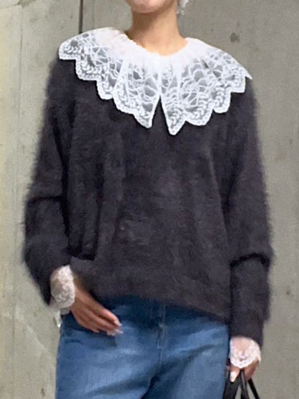 グレー系のニット/セーター、ホワイト系のシャツ/ブラウス、ブルー系のデニムパンツを着用したレディースの秋コーディネートの4枚目の写真