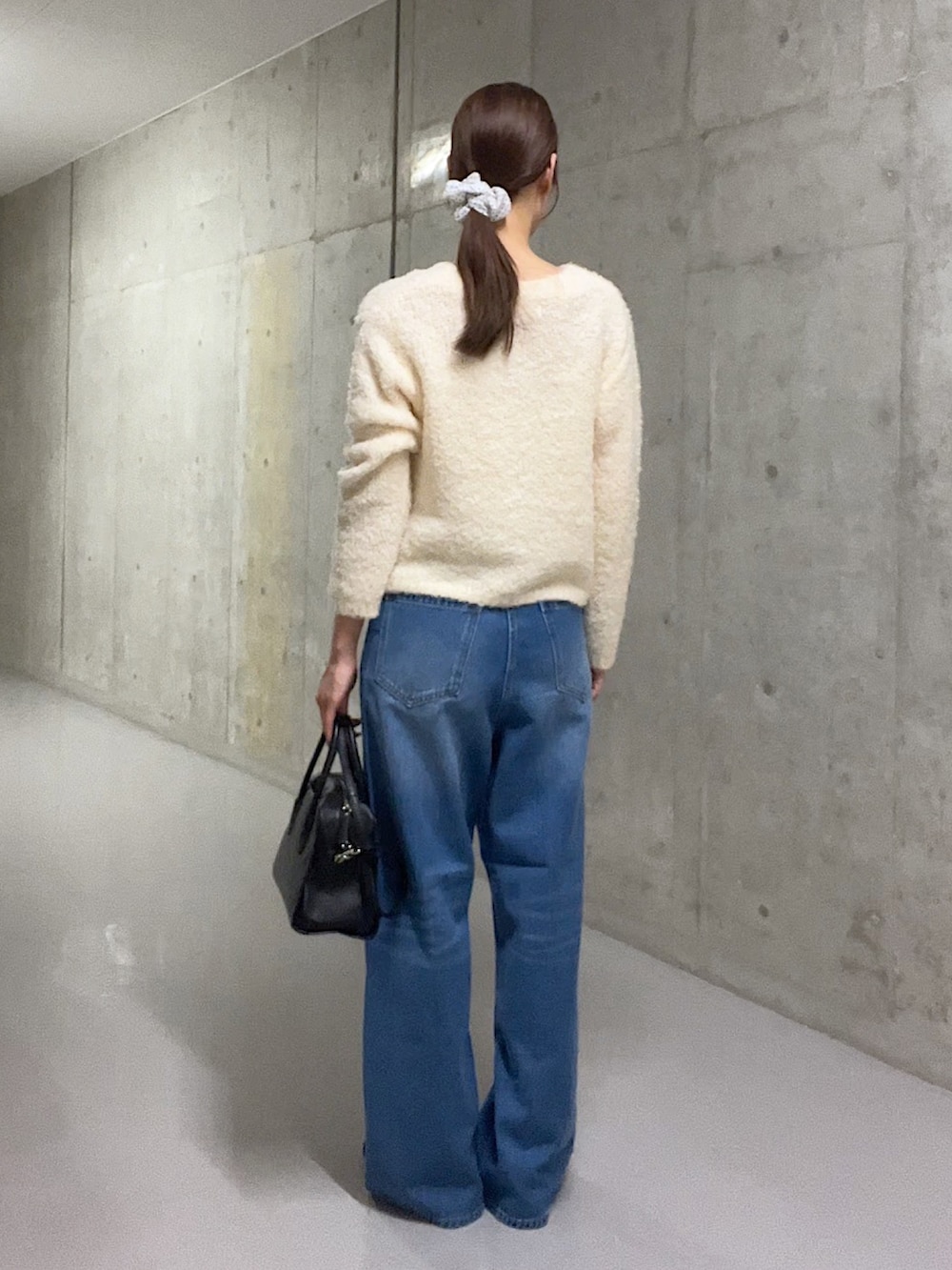 ホワイト系のカーディガン/ボレロ、ブルー系のデニムパンツ、ブラック系のローファーを着用したレディースの秋コーディネートの3枚目の写真