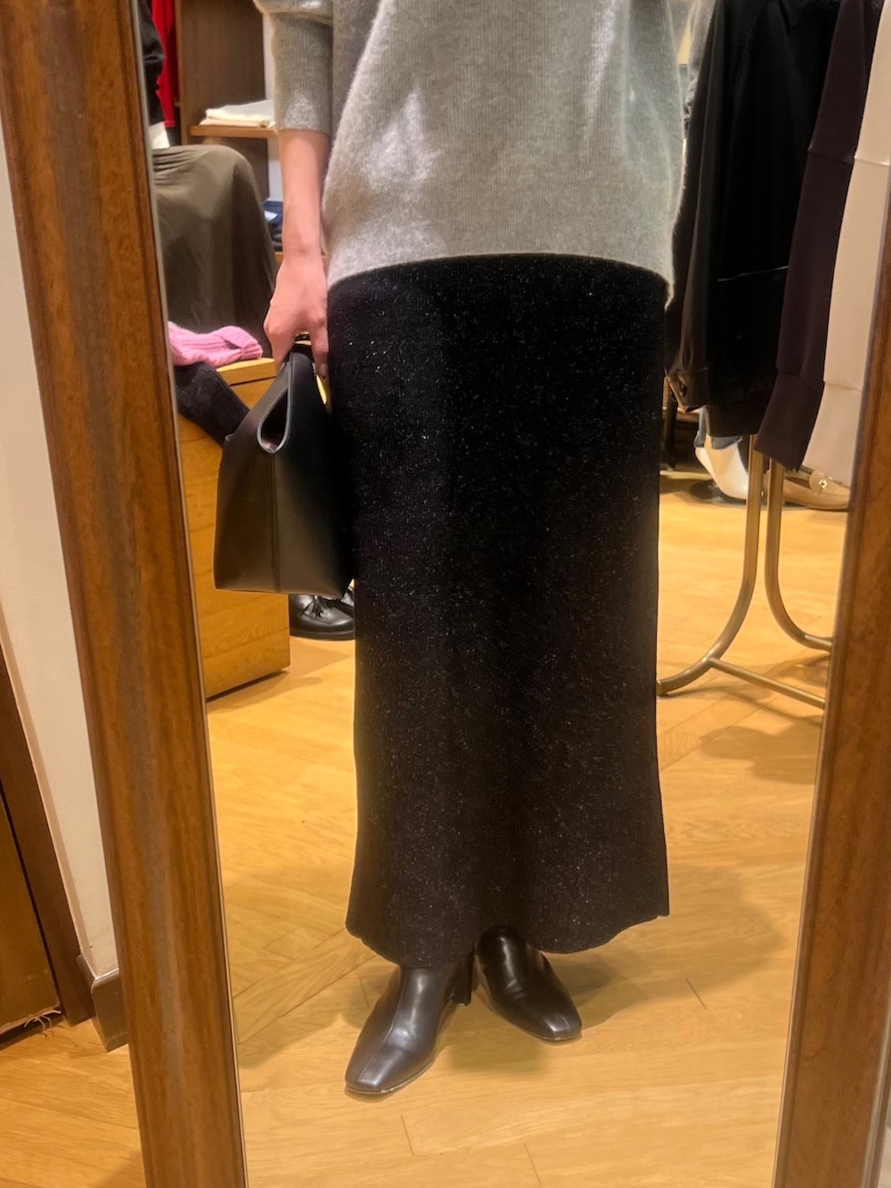 グレー系のニット/セーター、ブラック系のスカート、ブラック系のブーツを着用したレディースの冬コーディネートの4枚目の写真