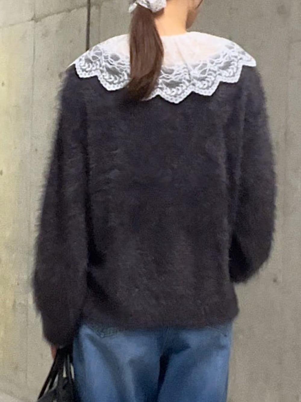 グレー系のニット/セーター、ホワイト系のシャツ/ブラウス、ブルー系のデニムパンツを着用したレディースの秋コーディネートの6枚目の写真