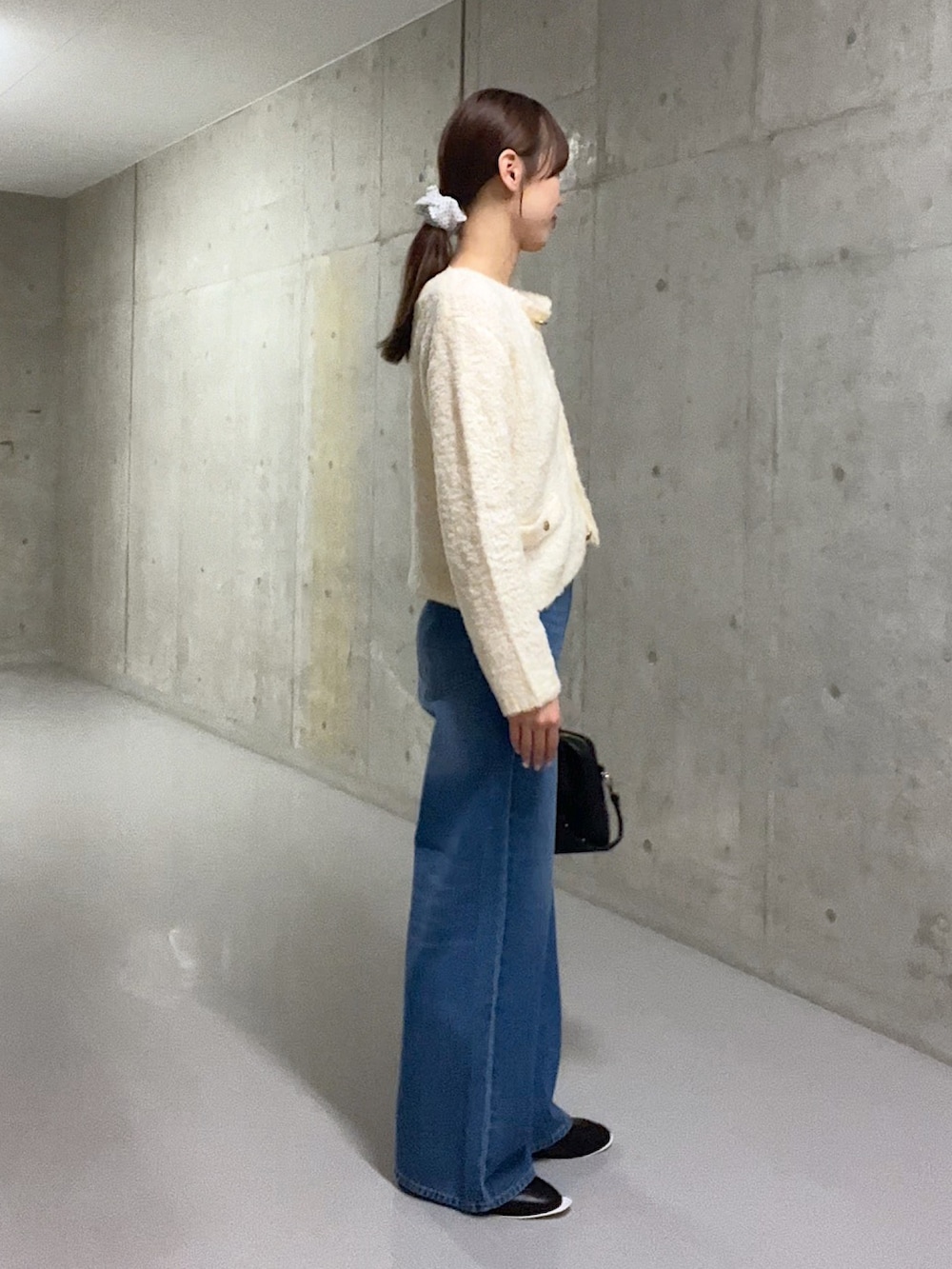 ホワイト系のカーディガン/ボレロ、ブルー系のデニムパンツ、ブラック系のローファーを着用したレディースの秋コーディネートの2枚目の写真