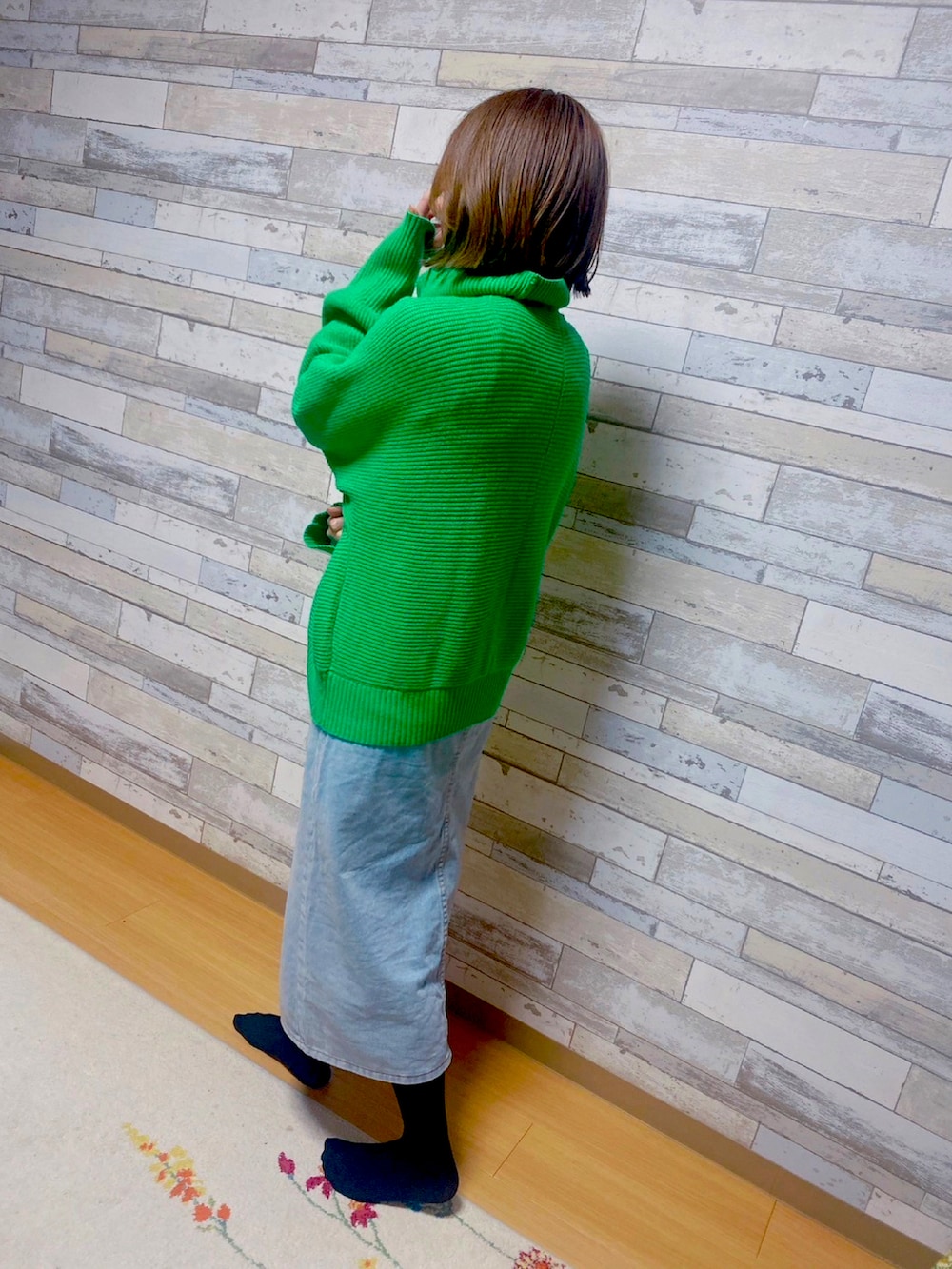 グリーン系のカーディガン/ボレロ、ブルー系のデニムスカートを着用したレディースの春コーディネートの2枚目の写真