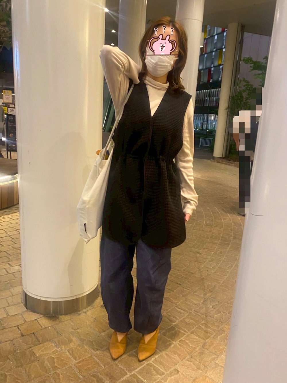 イエロー系のブーツ、ブルー系のその他パンツ、ブラック系のベストを着用したレディースの春コーディネートの2枚目の写真