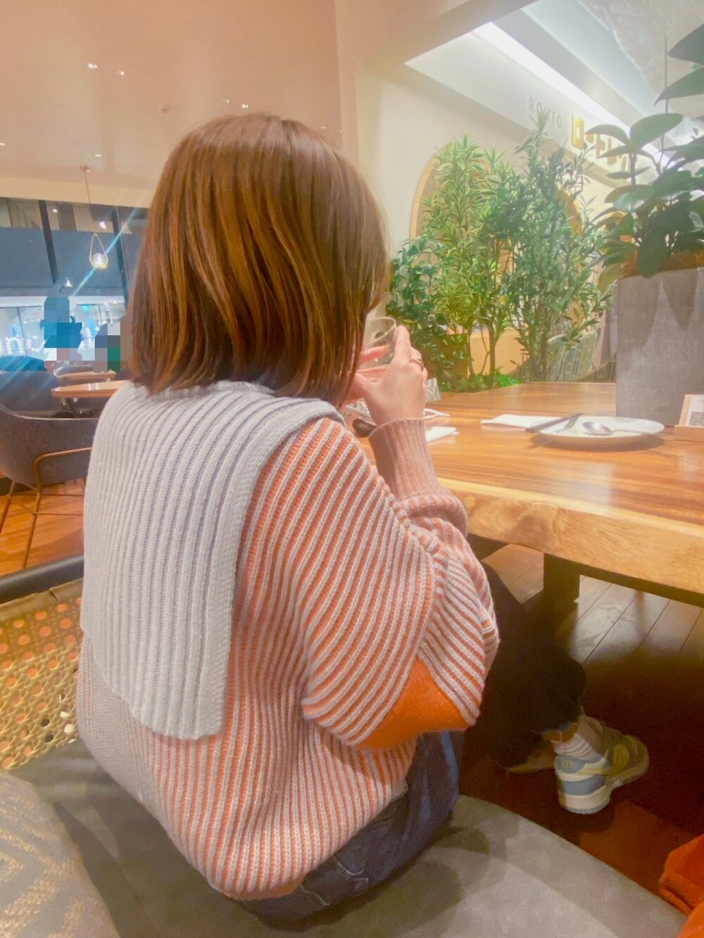 ブルー系のデニムパンツ、ホワイト系のスニーカー、ブラック系のビジネスバッグを着用したレディースの冬コーディネートの2枚目の写真