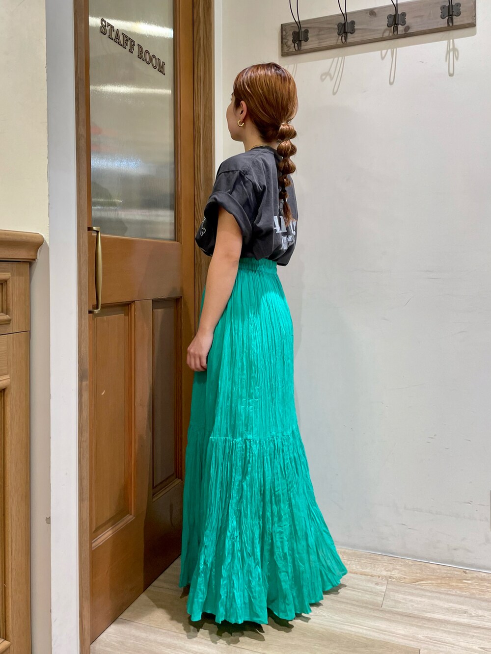 グリーン系のスカート、グレー系のTシャツ/カットソー、ブラック系のサンダルを着用したレディースの夏コーディネートの2枚目の写真