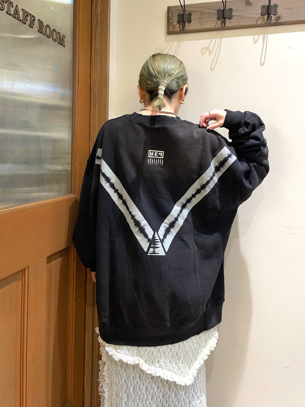 ブラック系のトップス、ホワイト系のスカート、ブラック系のブーツを着用したレディースの秋コーディネートの3枚目の写真