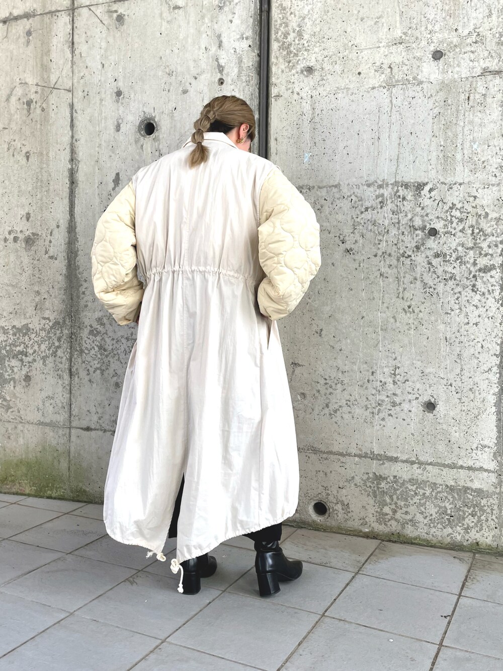 ホワイト系のノーカラーコート、ホワイト系のTシャツ/カットソー、ブラック系のその他パンツを着用したレディースの秋コーディネートの2枚目の写真