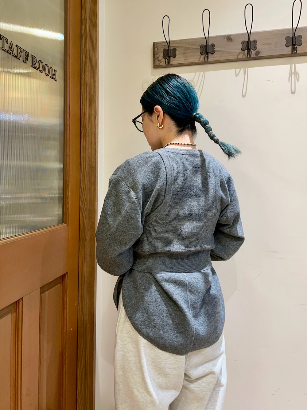 グレー系のニット/セーター、グリーン系のトートバッグを着用したレディースの冬コーディネートの4枚目の写真