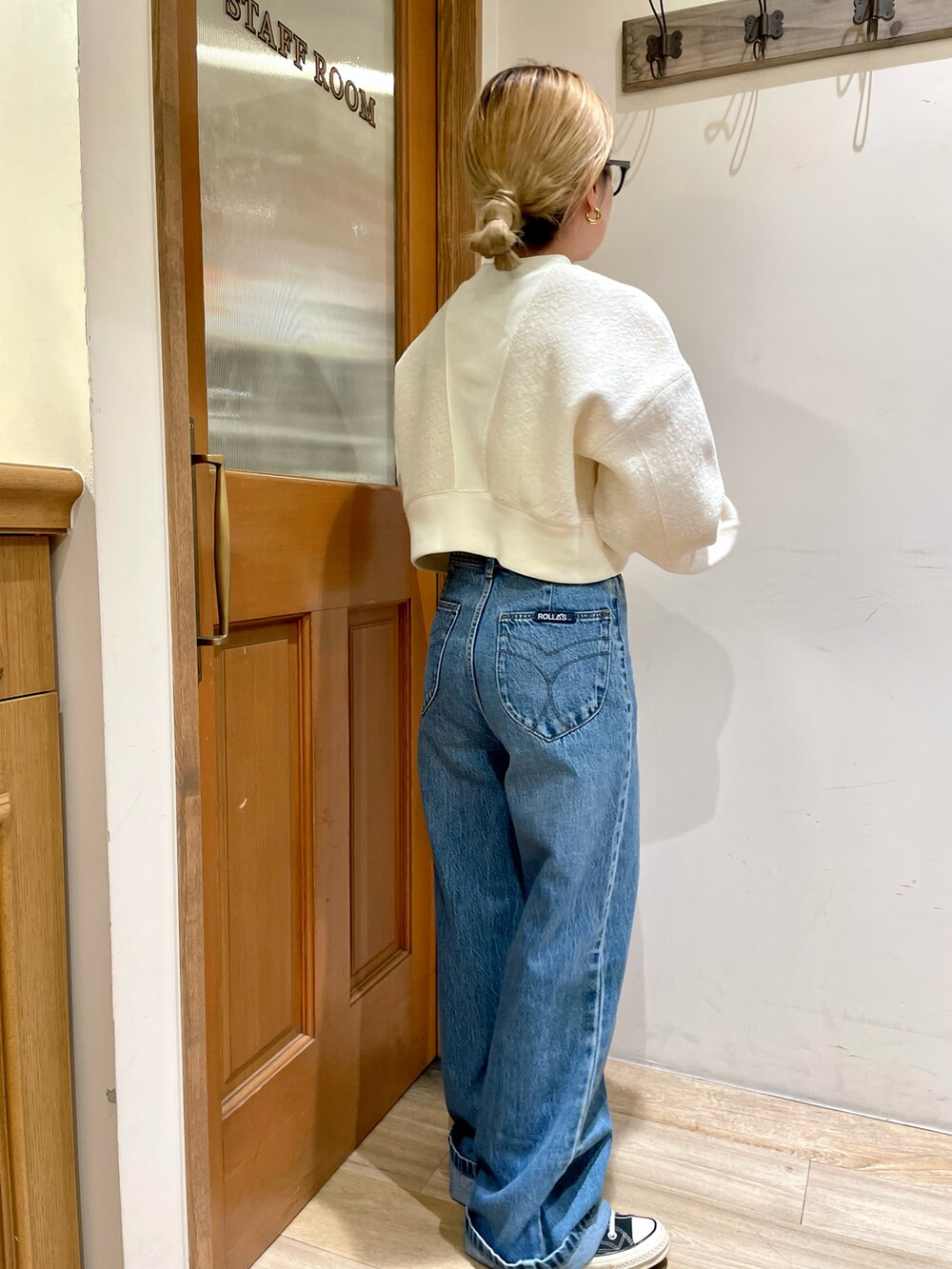 ブラウン系のステンカラーコート、ホワイト系のスウェット、ブルー系のデニムパンツを着用したレディースの秋コーディネートの4枚目の写真