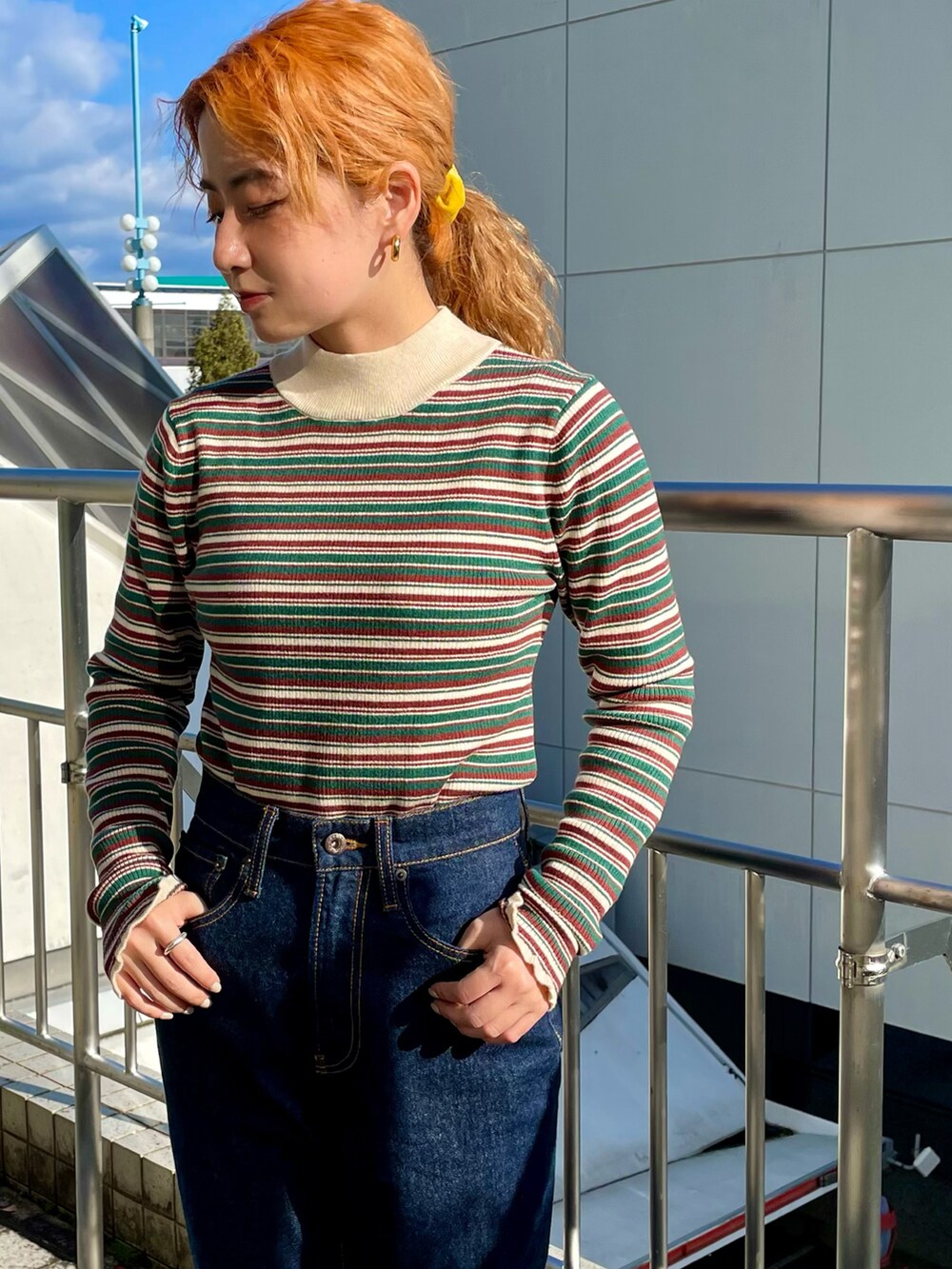 グリーン系のニット/セーター、ブルー系のデニムパンツ、ブラック系のブーツを着用したレディースの秋コーディネートの3枚目の写真