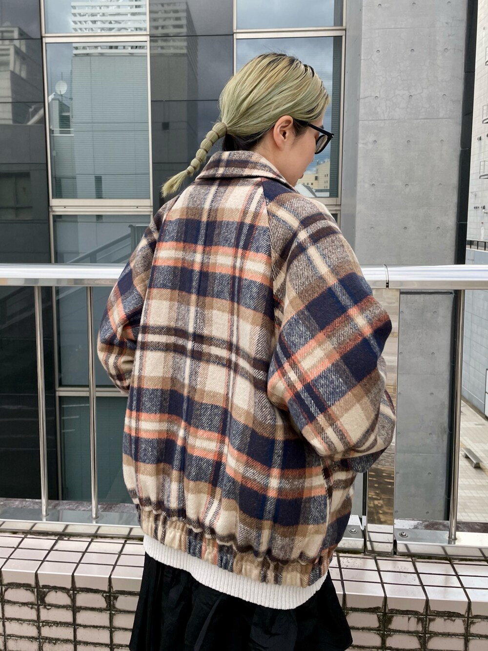 ホワイト系のニット/セーター、ブラウン系のブルゾン、ブラック系のスカートを着用したレディースの冬コーディネートの4枚目の写真