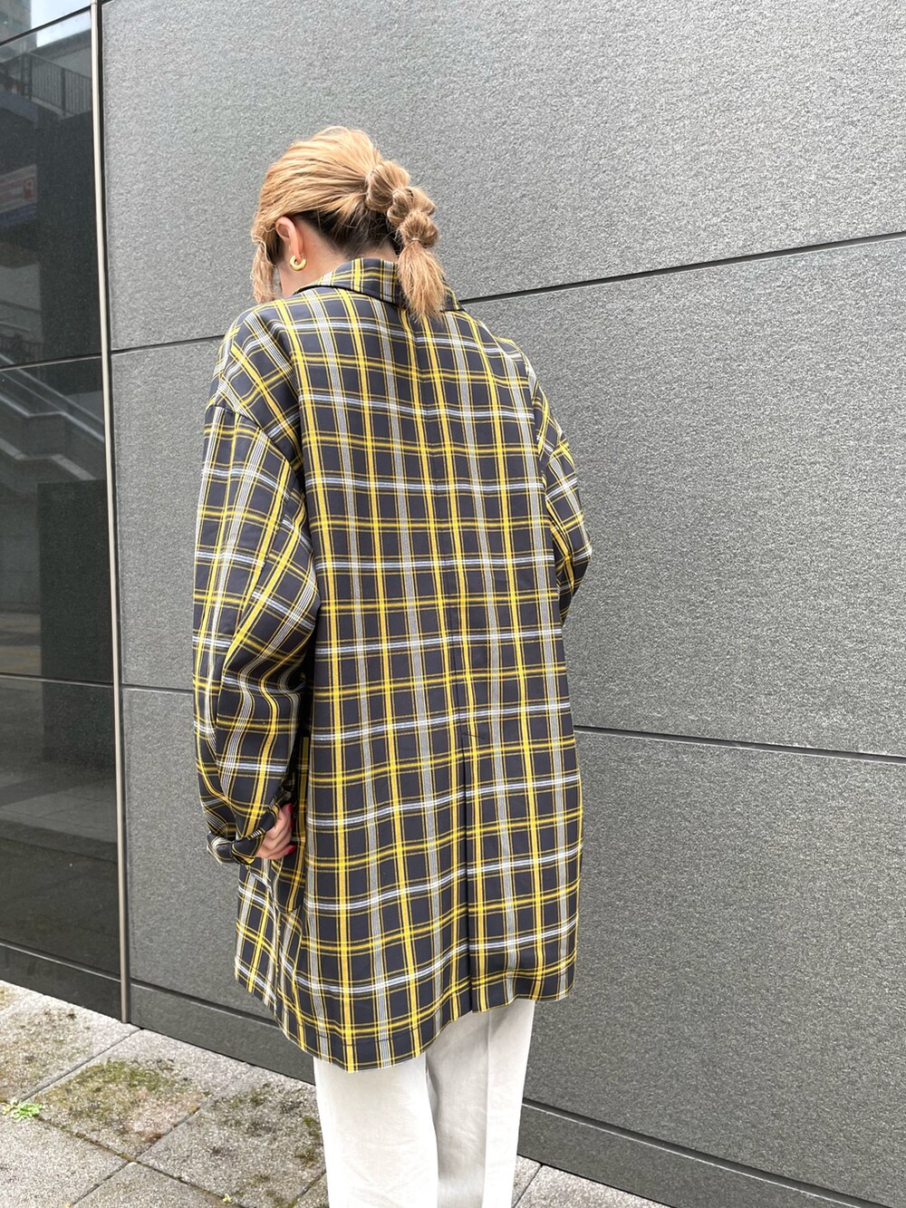 ブラック系のテーラードジャケット、ブラック系のハンドバッグ、グレー系のデニムパンツを着用したレディースの春コーディネートの3枚目の写真