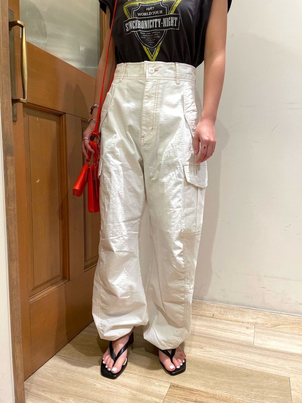 グレー系のTシャツ/カットソー、ホワイト系のカーゴパンツ、ブラック系のサンダルを着用したレディースの秋コーディネートの4枚目の写真