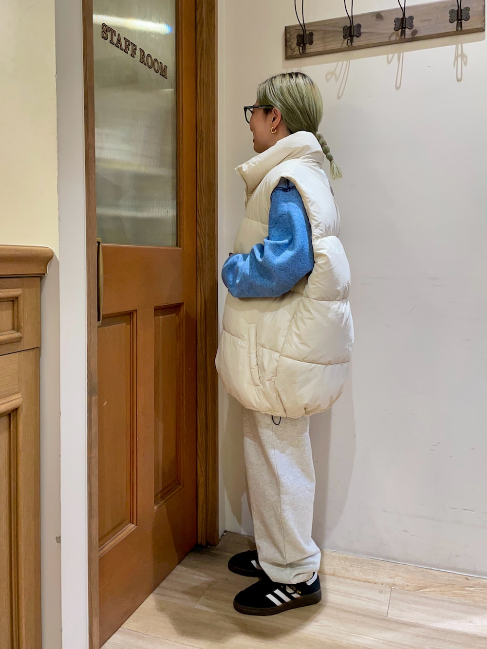 ホワイト系のダウンベスト、ブルー系のニット/セーターを着用したレディースの秋コーディネートの2枚目の写真