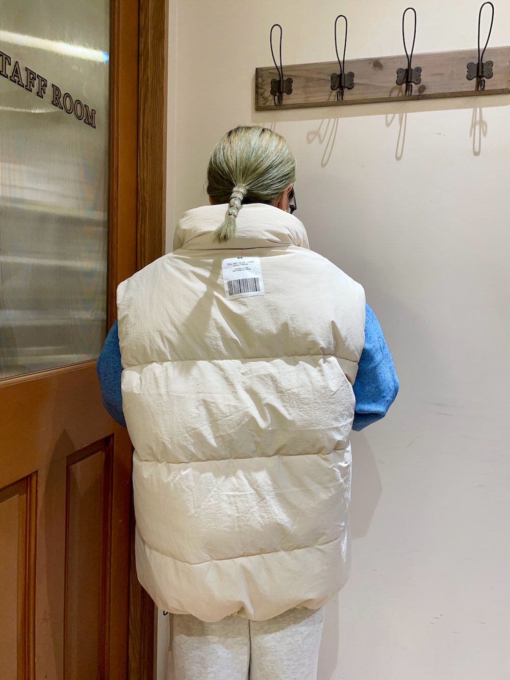 ホワイト系のダウンベスト、ブルー系のニット/セーターを着用したレディースの秋コーディネートの4枚目の写真