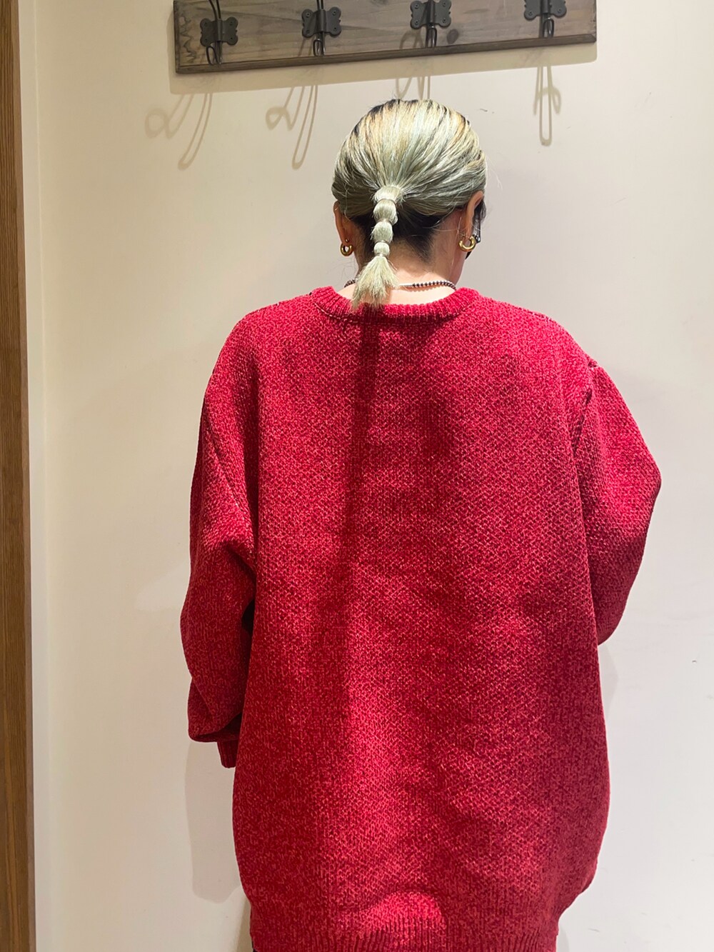 レッド系のニット/セーター、ブラック系のスカート、ブラウン系のハンドバッグを着用したレディースの秋コーディネートの4枚目の写真