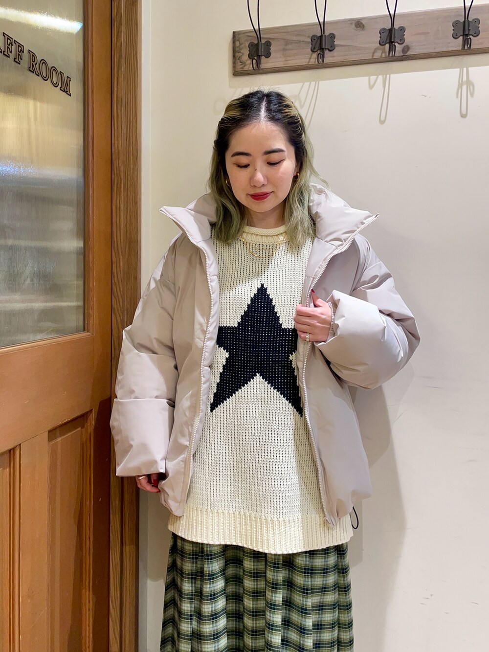 ホワイト系のニット/セーター、グレー系のダウンジャケット/コート、グリーン系のスカートを着用したレディースの冬コーディネートの3枚目の写真