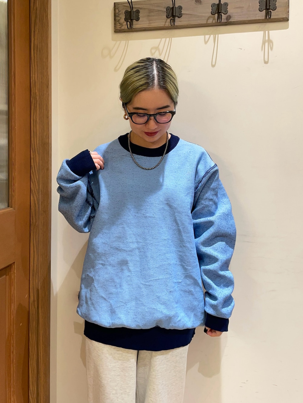 ホワイト系のダウンベスト、ブルー系のニット/セーターを着用したレディースの秋コーディネートの5枚目の写真